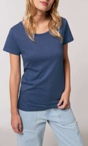 T-shirts écoresponsables empilés sur une table en bois avec étiquettes indiquant des matériaux biologiques et recyclés