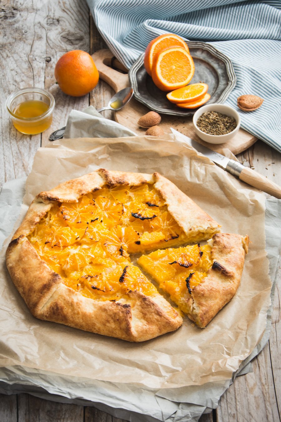 Oranges fraîches entassées avec des feuilles vertes sur fond de bois rustique